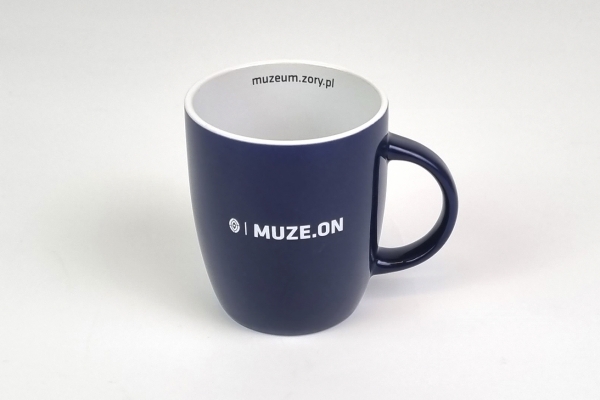 Kubek ceramiczny granatowy z grafiką i logotypem Muzeum Miejskiego w Żorach.
